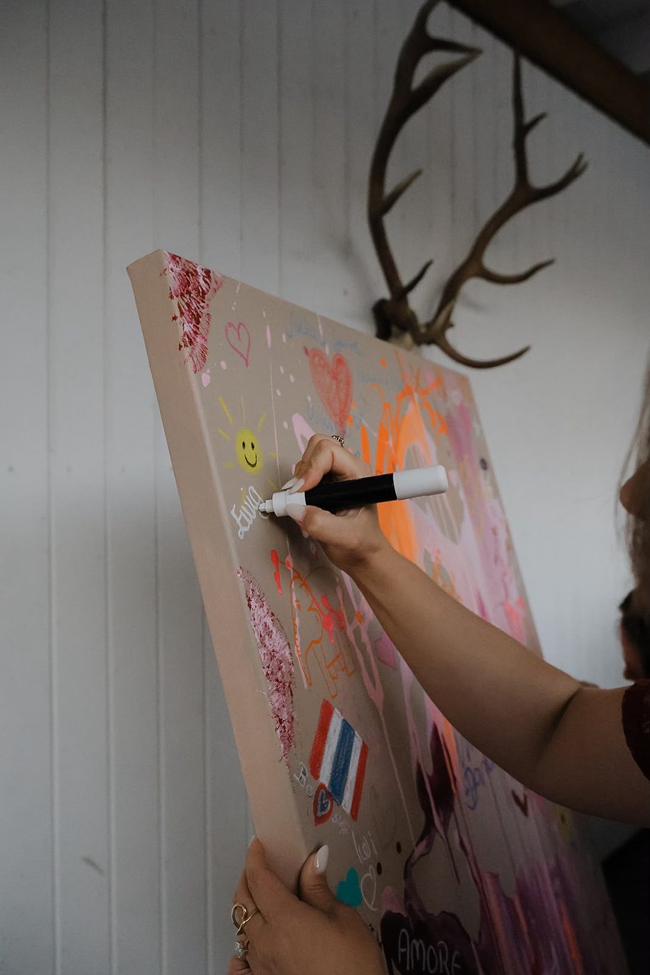 Eine Hand zeichnet mit Marker auf das Gästebuch-Kunstwerk